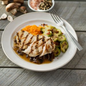 a prepared meal on a plate made by Silver Cuisine by BistroMD, with grilled chicken, brussel sprouts, and a mushroom sauce