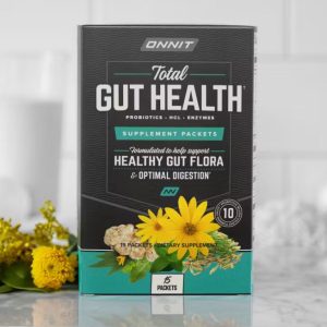 A box of Onnit Total Gut Health supplement packets, with a black and green label and an image of flowers on the front. The label mentions it supports healthy gut flora and optimal digestion.