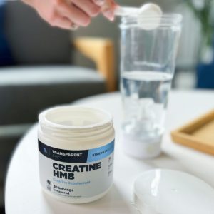 a product tester placing a scoop of transparent labs creatine hmb into a mixer