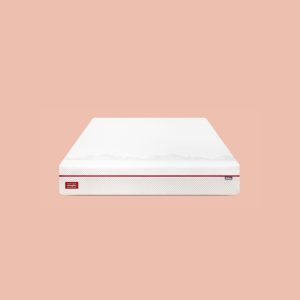 All-foam mattress with a white top and red side stripe, showcased against a peach-colored background