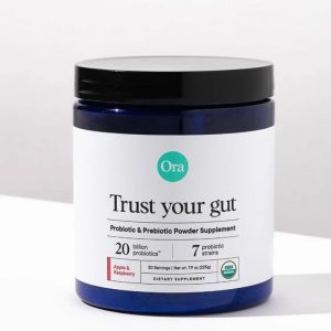 A jar of Ora Trust Your Gut probiotic and prebiotic powder supplement, containing 20 billion probiotics and 7 probiotic strains, with an apple and raspberry flavor, providing 30 servings.