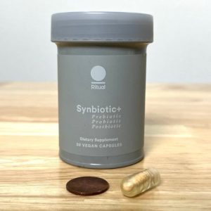 A container of Ritual Synbiotic+ dietary supplement, featuring prebiotic, probiotic, and postbiotic components. The bottle contains 30 vegan capsules.