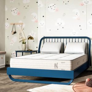 A Nolah Nurture mattress on a bed in a child’s room, featuring playful wall decor and a blue bed frame.