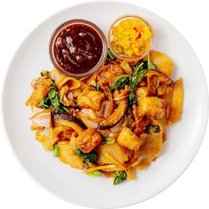 A plate of a finished CookUnity meal featuring stir-fried noodles with vegetables, tofu, and two small bowls of sauce.