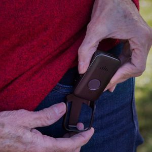 Bay Alarm mobile medical alert device being clipped onto a belt, easy-to-use with a single SOS button