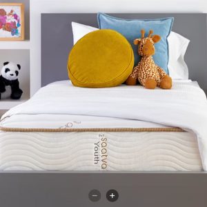 A Saatva Youth mattress on a bed with stuffed animals, showcasing a comfortable and inviting setup for children.