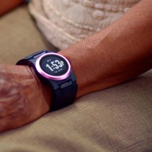 Smartwatch on wrist with digital time display, featuring a pink accent ring, optimized for elderly users.