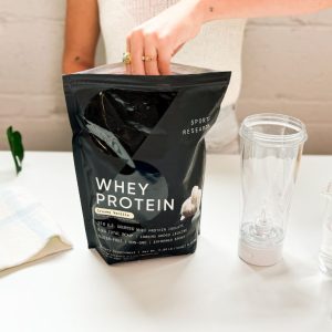 Tester scooping Sports Research Whey Protein out of the package