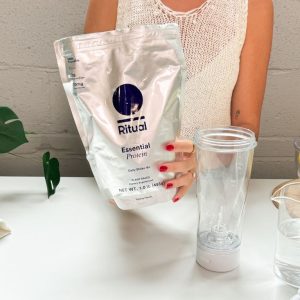 Person holding a bag of Ritual Essential Protein Daily Shake