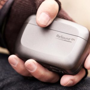 A hand holds a case of the LiNX Quattro by ReSound.